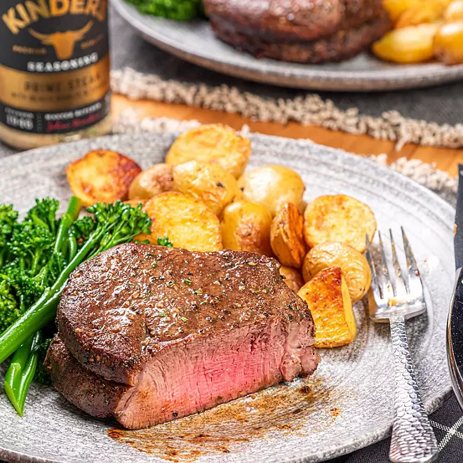 Sizzling ribeye steak in cast iron pan with herbs and butter