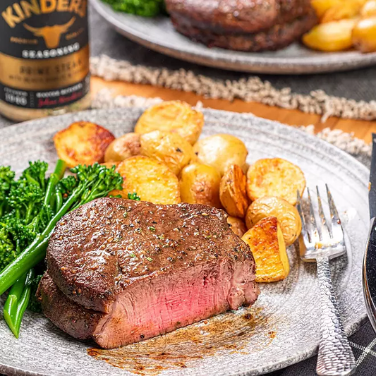 Sizzling ribeye steak in cast iron pan with herbs and butter