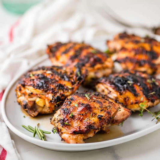 Crispy roasted chicken thighs with glaze and sweet heat seasoning on a tray